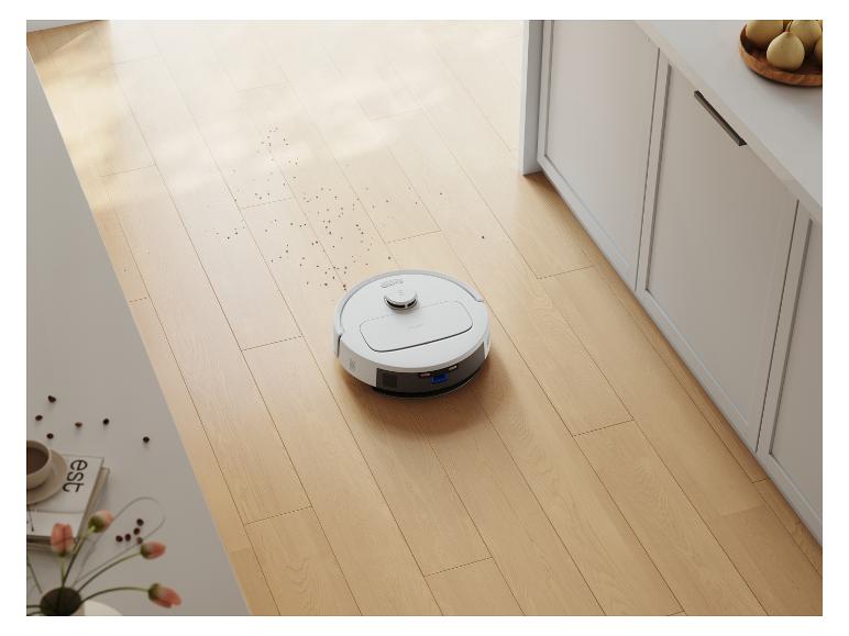 Een Deebot robotstofzuiger op een houten vloer.