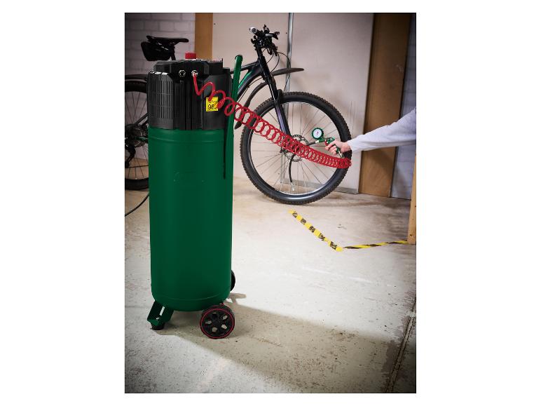 Luchtcompressor vult een fietsband, met een fiets op de achtergrond.