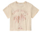 Een beige T-shirt met palmbomen en de tekst 'Sunset Beach'.