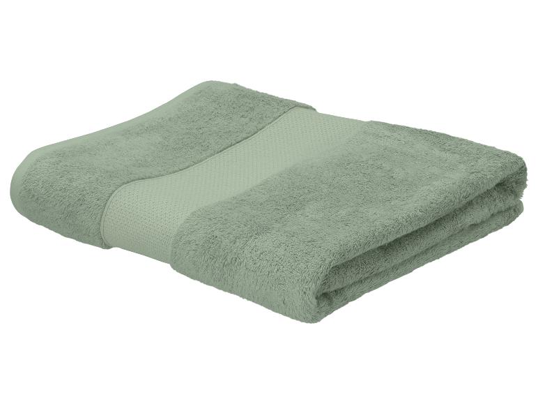 Gevouwen groene handdoek met een getextureerde rand.