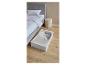 Slaapkamer met een bed en een opbergdoos onder het bed.