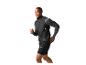 Lachende man in zwart hardloopvest en grijs shirt met lange mouwen, rennend.
