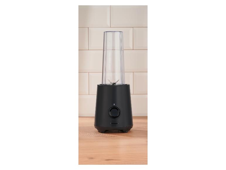Zwarte blender met transparante beker op een houten aanrecht.