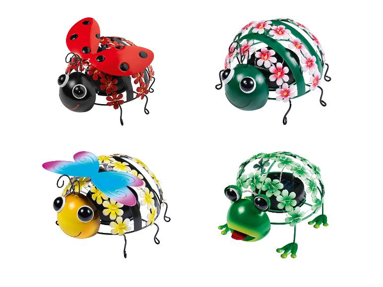 Vier metalen tuinfiguren met zonne-energie, waaronder een lieveheersbeestje, een bij, een kikker en een tweede lieveheersbeestje.