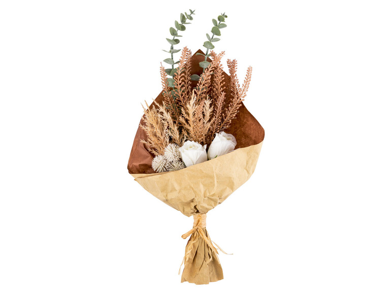 Een boeket met witte bloemen, droogbloemen en eucalyptus in bruin papier.
