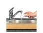 Hand spoelt filter onder stromend water in de gootsteen.
