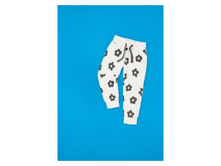 Witte broek met zwarte bloemen op een blauwe achtergrond.