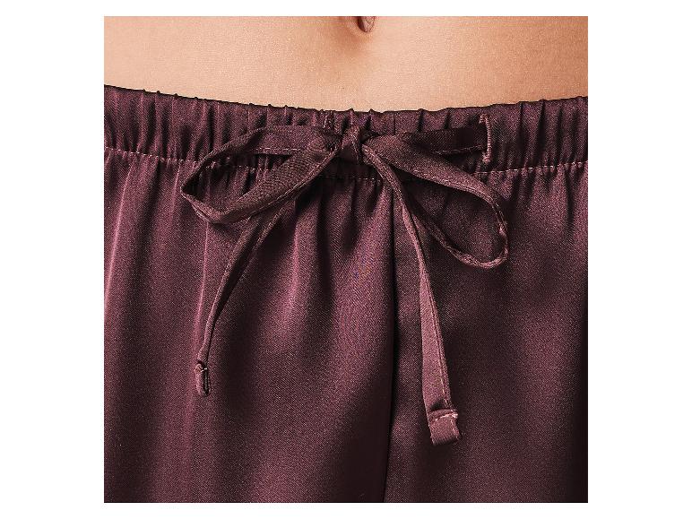 Close-up van een buik en een donkerbruine pyjamabroek met trekkoord.