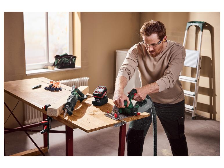 Man zaagt een houten plank met een cirkelzaag, met veiligheidsbril op.