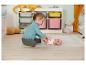 Een meisje speelt met een Baby Born pop in een kinderkamer.