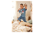 Kind in Paw Patrol pyjama springt op bed.
