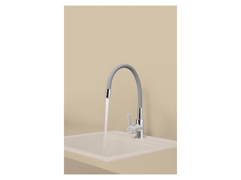 Keukenkraan met een grijze flexibele uitloop en stromend water in een beige spoelbak.