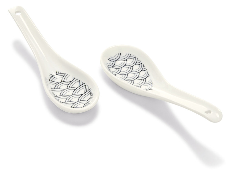 Twee witte soeplepels met een Japans golvend patroon.