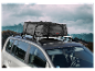 Een Ultimate Speed dakkoffer op een auto, met een bergachtig landschap op de achtergrond.