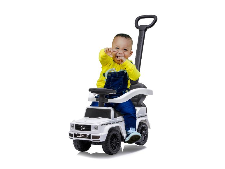 Een klein kind speelt met een Mercedes-Benz G-klasse speelgoedauto.