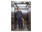 Man in grijs shirt en donkerblauwe broek met bloemenboeket in een lift.