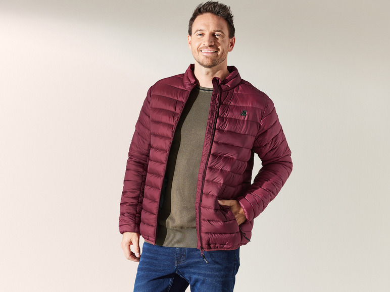 Man draagt een donkerrode jack en jeans.