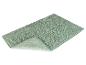 Een lichtgroene badmat met een zachte, geribbelde onderkant.