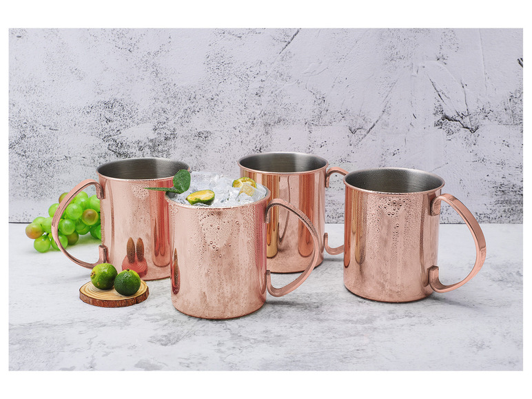 Drie koperen Moscow Mule bekers met ijs en limoen.