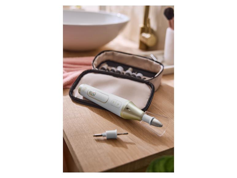 Manicure- en pedicureset met elektrische vijl op een houten badkamerblad.