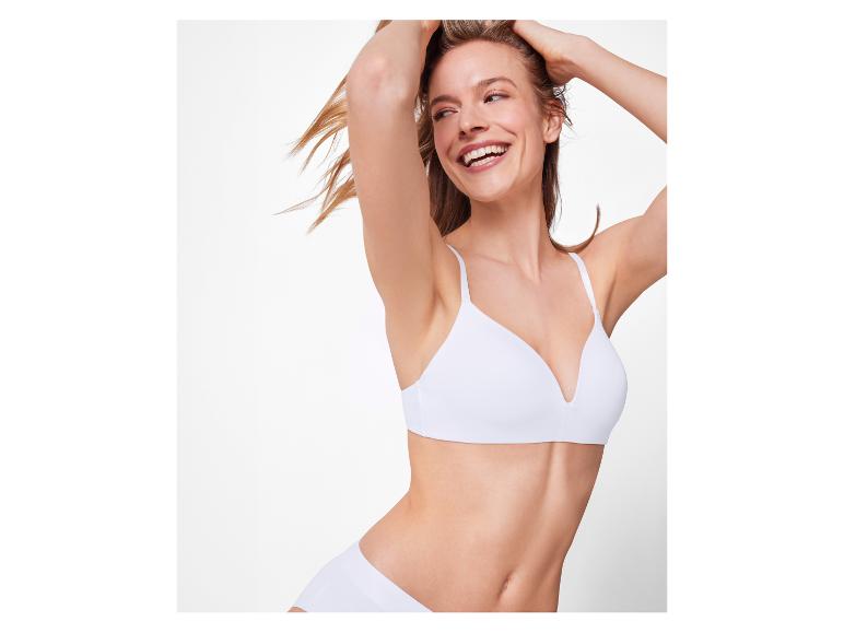 Lachende vrouw in witte bh en slip.