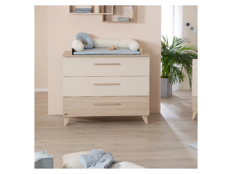 Babykamer met commode, planken en planten.
