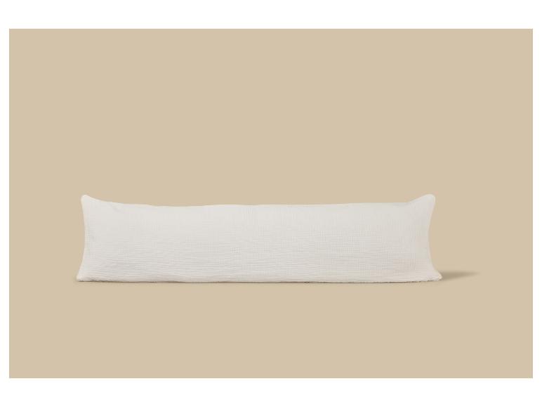 Wit getextureerd lichaamskussen op een beige achtergrond.
