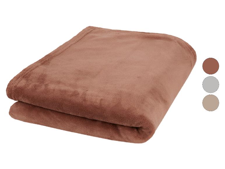 Bruine fleece deken opgevouwen met kleurstalen ernaast.