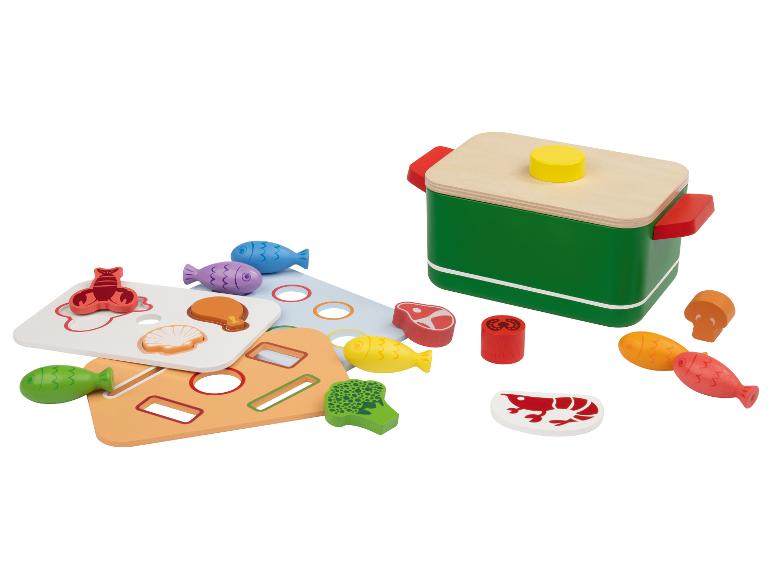 Houten speelset met een pot en etenswaren, waaronder vis, vlees en groenten.