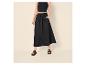 Vrouw in zwarte crop top, lange rok en sandalen.