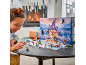 Kind speelt met een speelgoedadventskalender aan een tafel voor een open haard.