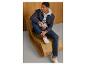 Man zittend in een sweat denim jeans, blauwe jas en witte sneakers.