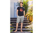 Man draagt ​​een zwarte T-shirt met print en grijze shorts.