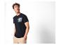Man in een marineblauw T-shirt met auto- en palmboomprint, en een beige broek.