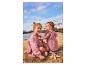 Twee meisjes in roze jurken zitten op het zand bij het water, met zeesterren.