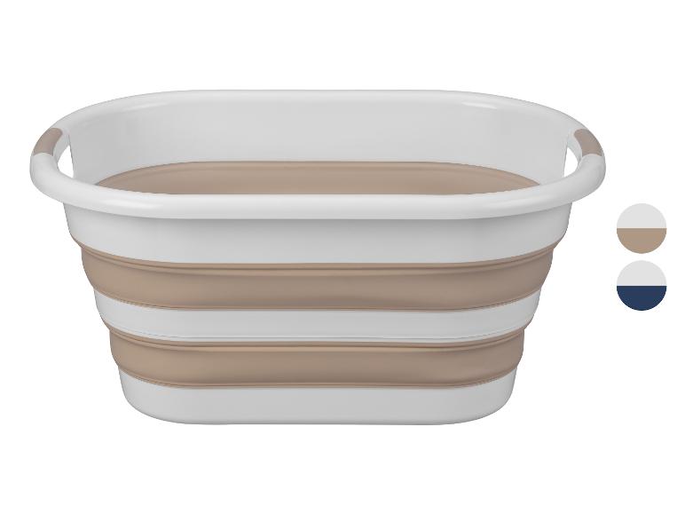 Opvouwbare wasmand in wit en beige.
