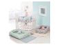 Wit zeshoekig babybedje met blauw matras, twee babynestjes met knuffels en vloerkleden.