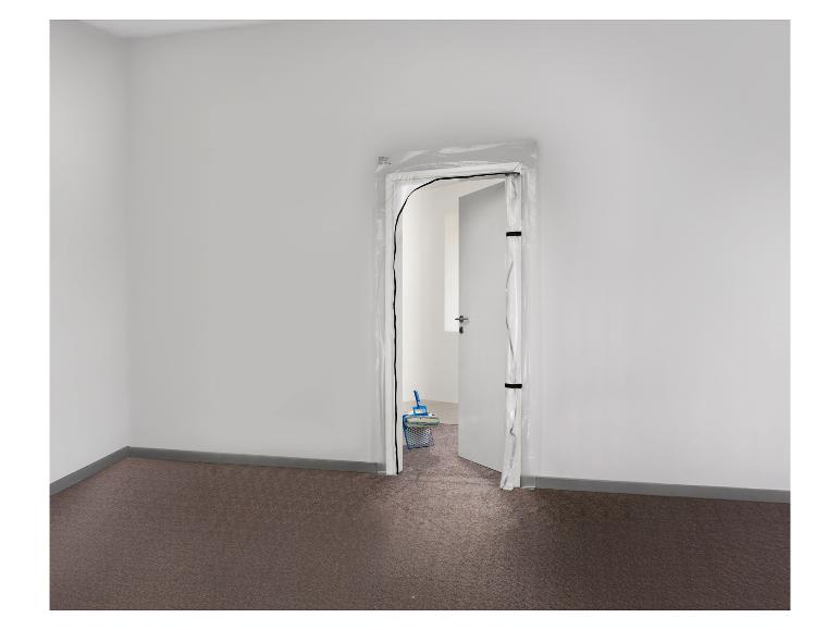 Stofdeur met rits, met schildergereedschap op de achtergrond