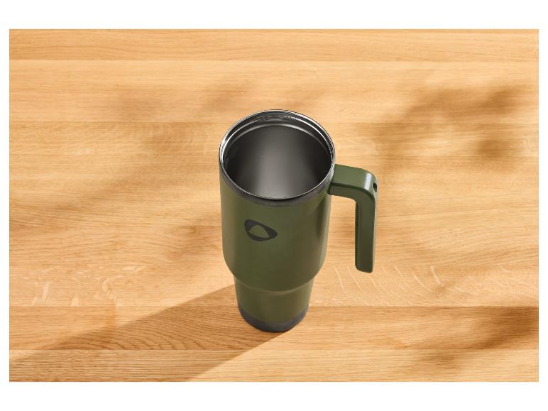 Groene thermosbeker met handvat op een houten tafel.