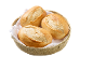 Drie versgebakken broodjes in een rieten mand met een wit servet.