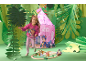 Meisje in roze sweatshirt en broek, naast roze speeltent en houten treinset.