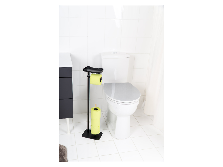 Zwarte toiletrolhouder met limoengroene toiletrol in een witte badkamer.