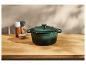 Groene gietijzeren pan op een houten aanrecht.
