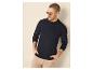 Man in een donkerblauwe polo met lange mouwen en beige broek, met zonnebril.