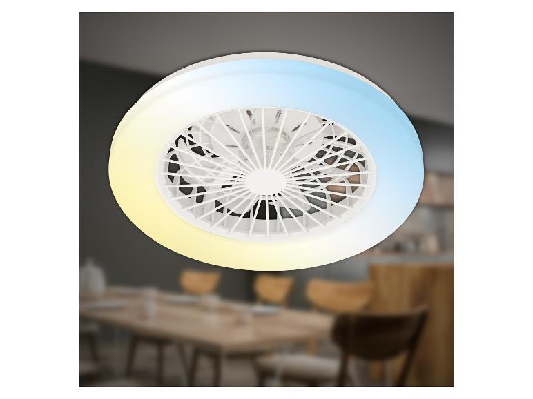 Witte plafondventilator met LED-licht, met een wazige achtergrond van een eetkamer.