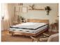 Slaapkamer met houten bed, matras en topper, nachtkastjes en decoraties.