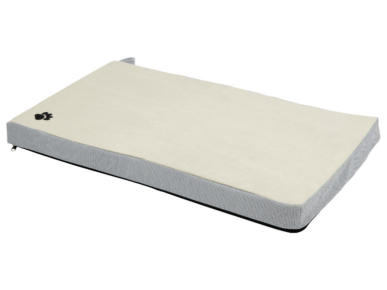 Een beige hondenbed met grijze rand.