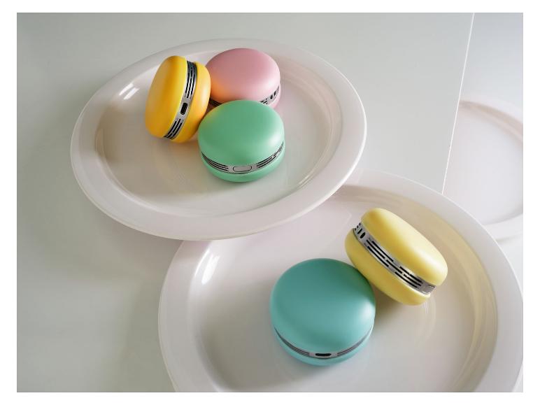 Kleurrijke macaronvormige miniventilatoren op witte borden.