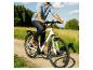 Man op witte elektrische fiets met 'TELEFUNKEN' op frame, rijdend op een landweg.