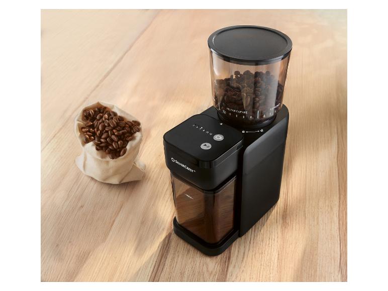 Zwarte SILVERCREST koffiemolen met transparant bonenreservoir en een zakje koffiebonen.